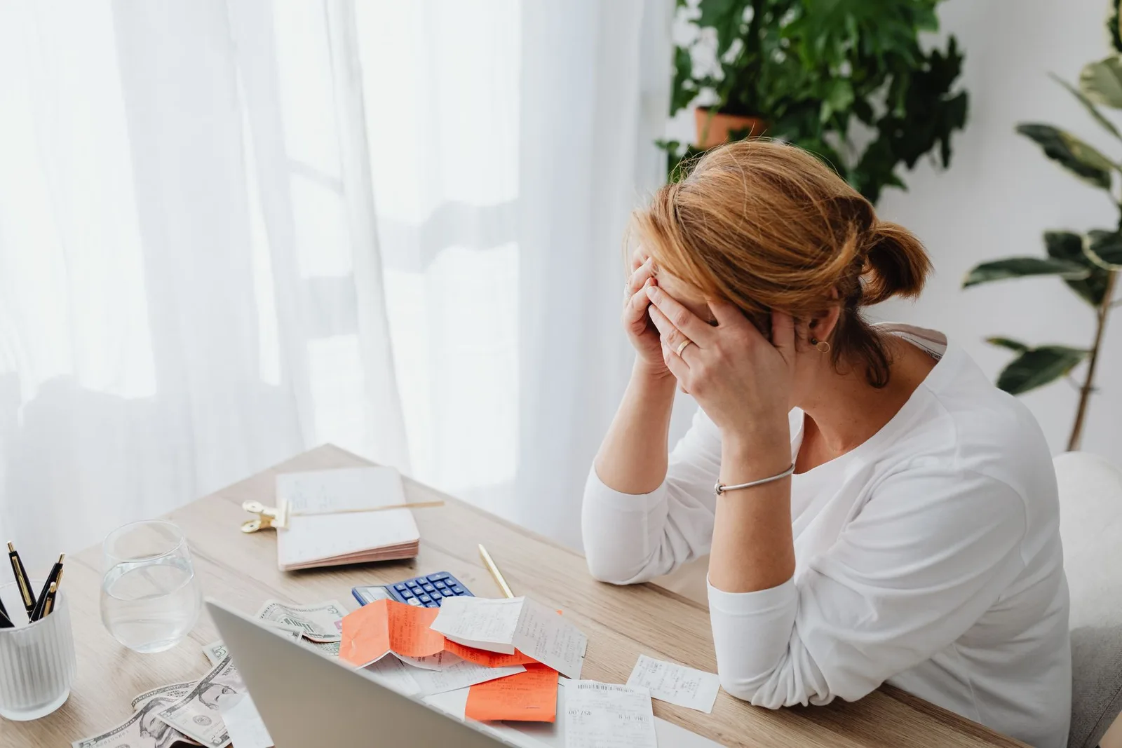 A creator at a desk looking stressed while going through payment receipts