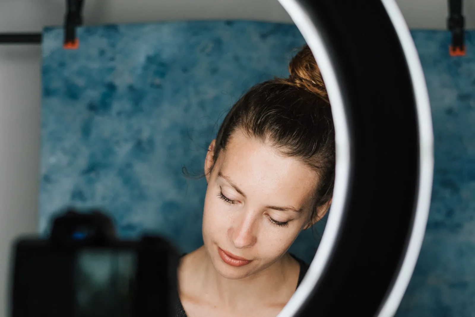 A creator recording a video lesson with a camera and ring light