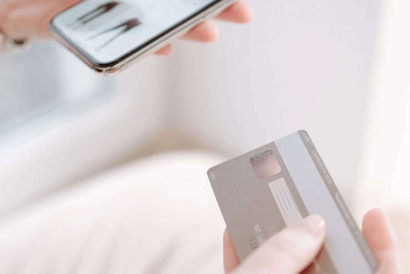 A buyer paying for a digital product on a phone with a card in hand